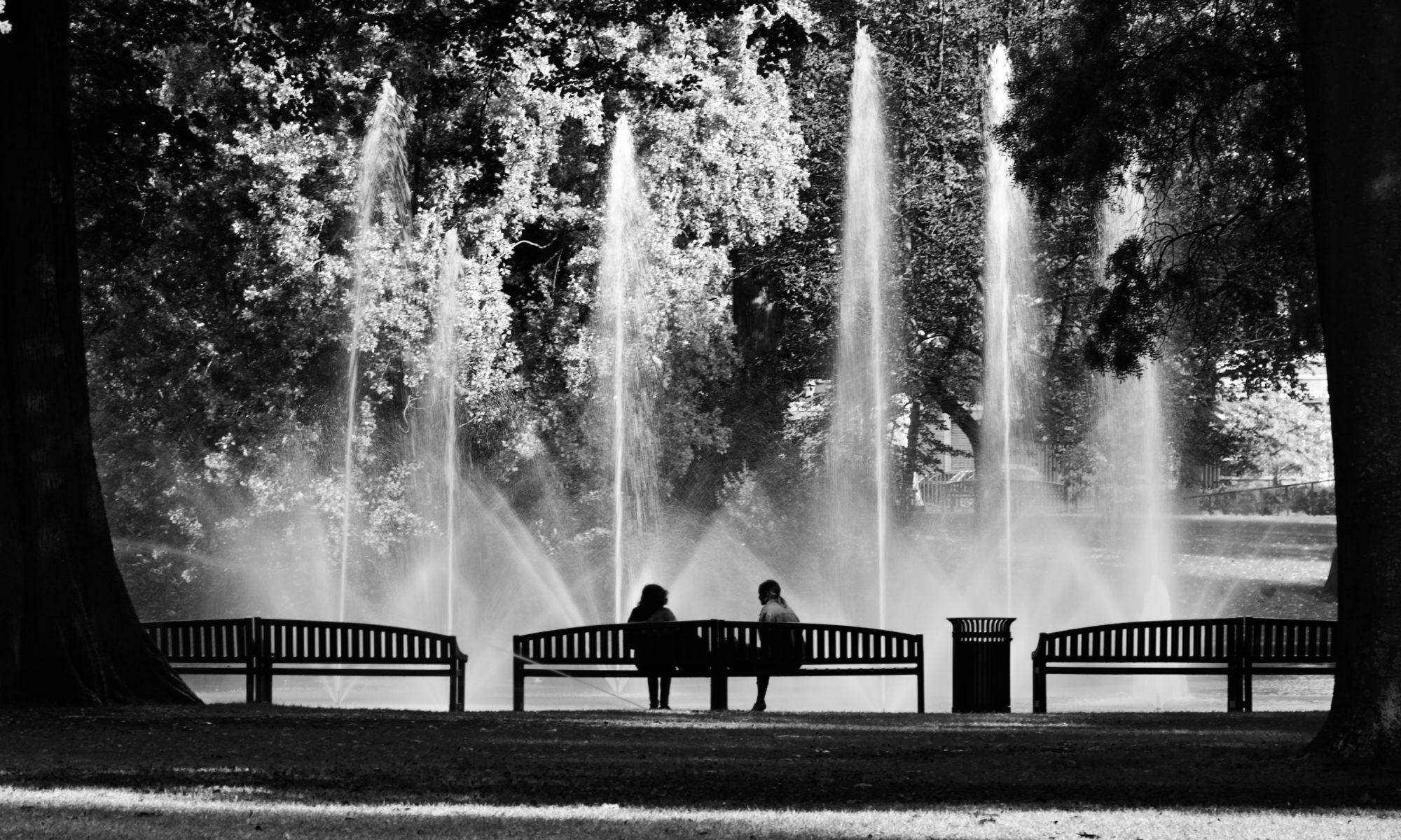 Two girls sitting on a bench in the park